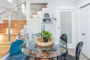 a dining room with a glass table and chairs at Cozy Duplex Near T in Boston