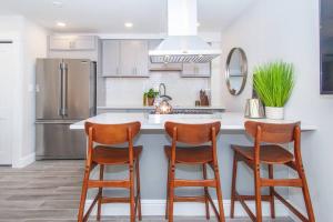 a kitchen with a counter with chairs and a refrigerator at Cozy Duplex Near T in Boston +33 photos