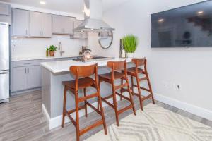 a kitchen with a kitchen island with four chairs at Cozy Duplex Near T in Boston