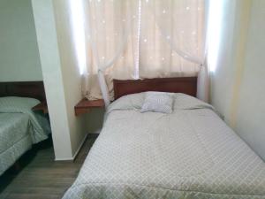 a small bedroom with a bed and a window at Callihotel in Tehuacán