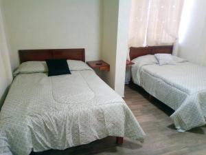 a bedroom with two beds and a window at Callihotel in Tehuacán