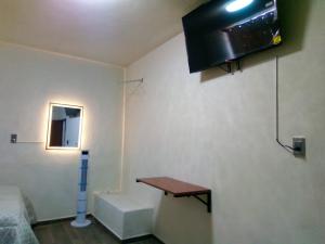 a room with a table and a tv on the wall at Callihotel in Tehuacán
