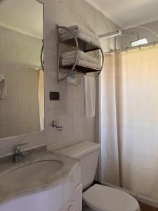 a bathroom with a sink and a toilet and a mirror at Cabaña Castaño in Villarrica +18 photos