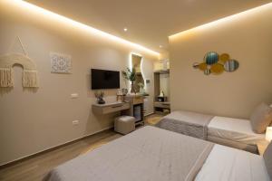 a hotel room with two beds and a television at Del Mare Rooms in Vlorë