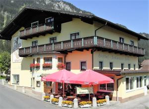 ein Gebäude mit zwei rosa Sonnenschirmen davor in der Unterkunft Hotel Restaurant Kröll in Reutte