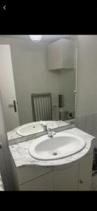 a bathroom with a white sink and a mirror at Studio cosy in Boutx