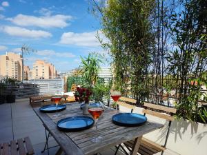 a wooden table with glasses of wine on a balcony at Penthouse 166 m2- Terrasse & Parking - Paris Sud - Orly - Parc Expo in Bagneux
