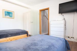 a bedroom with two beds and a flat screen tv at Monteurunterkunft Kuddel in Laboe