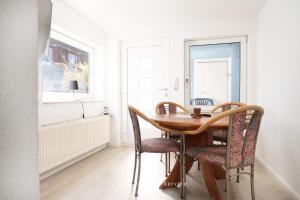 a dining room with a wooden table and chairs at Monteurunterkunft Kuddel in Laboe