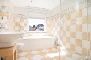 a bathroom with a sink and a toilet and a window at Monteurunterkunft Kuddel in Laboe +16 photos