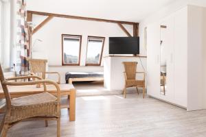 a living room with a table and chairs and a tv at Monteurunterkunft Kuddel in Laboe