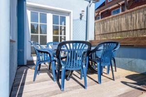 a group of blue chairs and a table on a porch at Monteurunterkunft Kuddel in Laboe