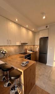 a kitchen with a wooden counter and a refrigerator at Apartament Wiosenna in Białystok