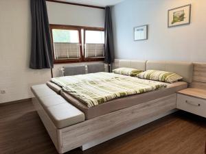 a large bed in a room with a window at Ferienwohnung Ulbricht mit aktivCARD in Sankt Englmar +105 photos