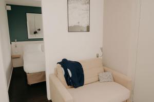 a living room with a white couch with a black backpack on it at Kyriad Quimper Sud in Quimper +95 photos