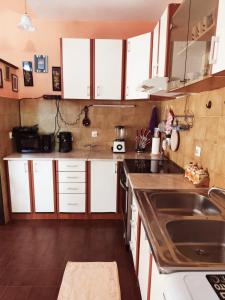 a kitchen with white cabinets and a sink at Sunshine Apartment in Dobrota +5 photos