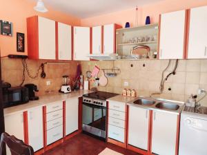 a small kitchen with white cabinets and a sink at Sunshine Apartment in Dobrota