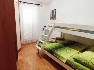 a bedroom with a bunk bed with a ladder at Sunshine Apartment in Dobrota
