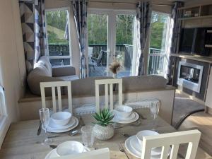 a dining room with a table and chairs and a couch at Snug on the Teviot in Hawick