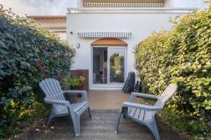 two chairs sitting on a porch in front of a house at Charmant studio climatisé à deux pas de la plage! in Anglet