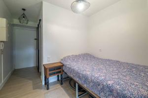a bedroom with a bed and a table and a door at Charmant studio climatisé à deux pas de la plage! in Anglet