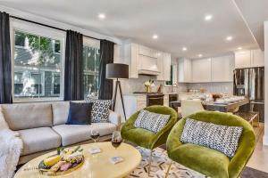 a living room with a couch and chairs and a kitchen at Luxe Boston Condo Near T in Boston +9 photos