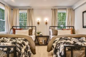 a bedroom with two beds and a table and windows at Luxe Boston Condo Near T in Boston
