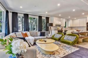 a living room with a couch and chairs and a kitchen at Luxe Boston Condo Near T in Boston