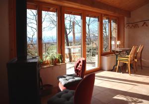 a living room with chairs and a table and windows at La Forge - calme absolu avec vue sur les Pyrenées in Villarzel-du-Razès