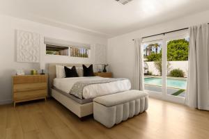 a white bedroom with a bed and a sliding glass door at Private Pool Escape Casita Mini Golf 4BR in Indio +50 photos