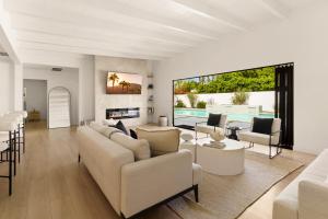 a living room with white furniture and a large window at Private Pool Escape Casita Mini Golf 4BR in Indio