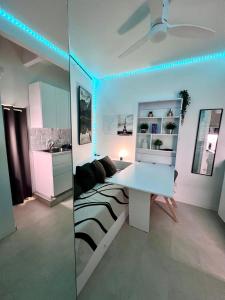 a white room with a bed and a desk in it at Mini-studio de 15m2 à 8 min de Paris in Maisons-Alfort