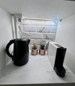 a coffee pot sitting on a counter next to a microwave at Mini-studio de 15m2 à 8 min de Paris in Maisons-Alfort