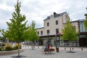 two people sitting on a bench in front of a building at Mini-studio de 15m2 à 8 min de Paris in Maisons-Alfort