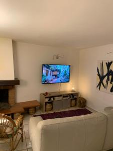 a living room with a white couch and a flat screen tv at Vicolo Castellaccio in Massa