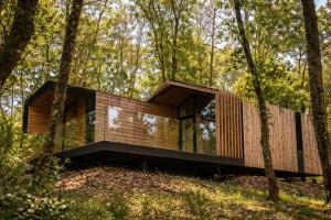 a house in the woods with a large window at Cabañas en Ribeira Sacra, Borbela de Luz in Villar de Ordelles