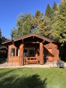 a log cabin with a bench in front of it at Cabaña Coihue in Pucará