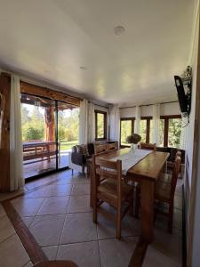 a dining room with a wooden table and chairs at Cabaña Coihue in Pucará