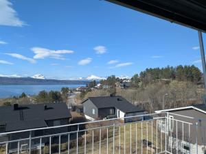 ein Blick vom Balkon eines Hauses mit See und Bergen in der Unterkunft Aurora Fjord View Escape Narvik garden sleeps 10 in Narvik