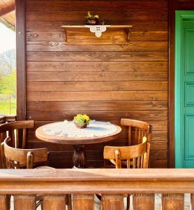 a table and chairs in a room with a wooden wall at Selsko domacinstvo Nevena in Kumanovo