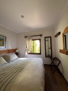 a bedroom with a large bed and a window at Cabaña Coihue in Pucará