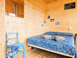a bedroom with a bed and a blue chair at Nido de mar & Nido de Paola in Mazo