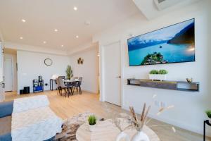 a living room with a couch and a tv on a wall at Stylish Open Concept Suite in Central KW in Kitchener