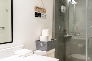 a bathroom with a shower and a toilet and towels at Stylish Open Concept Suite in Central KW in Kitchener +36 photos