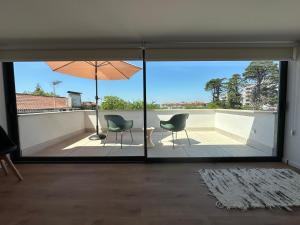 a living room with two chairs and an umbrella at Loft Azeméis in Oliveira de Azemeis