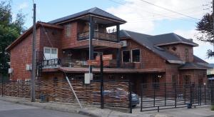 Casa de ladrillo con balcón en una calle en Hotel boutique Refugio de Navegantes, en Dalcahue