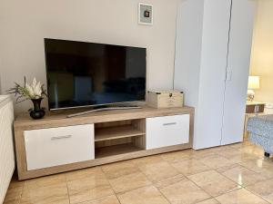 a living room with a television on a wooden entertainment center at Vintage Apartman Gyula in Gyula