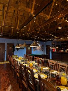 a long wooden table in a restaurant with chairs and drinks at Stara Fabryka Myślniew in Myślniew +53 photos