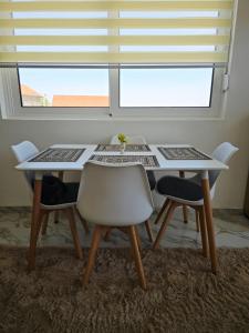 a dining room table with two chairs and a window at Brita Apartman in Utjeha +13 photos