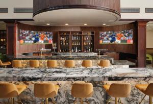 a bar with a large marble table and chairs at Hotel Dax in Addison